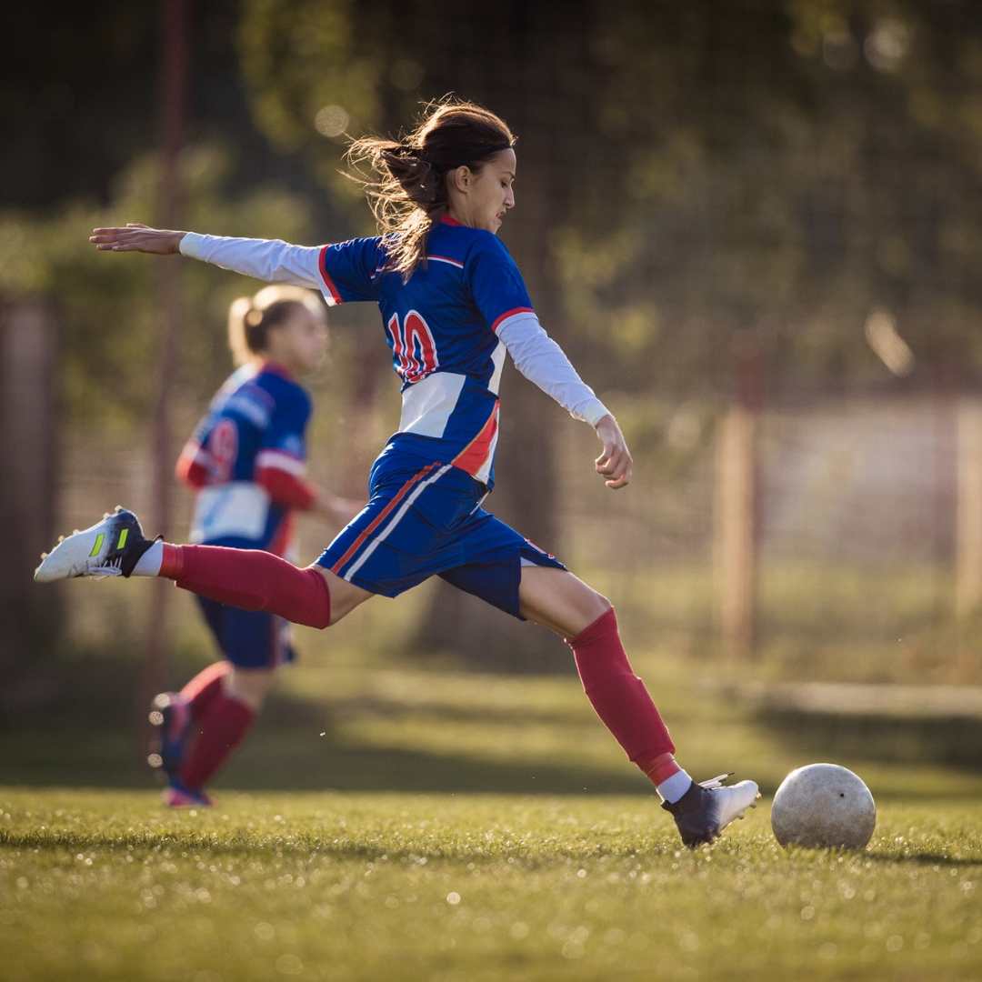 woman kicking soccer ball